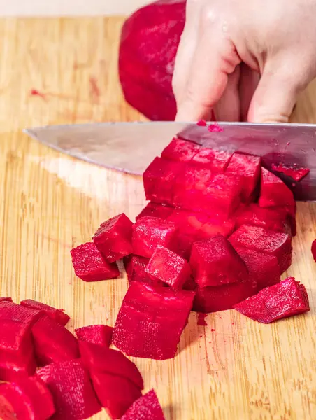 Cocinero corta remolacha roja en una tabla de madera — Foto de Stock