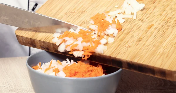 Şef ezilmiş soğan ve havuç döker 