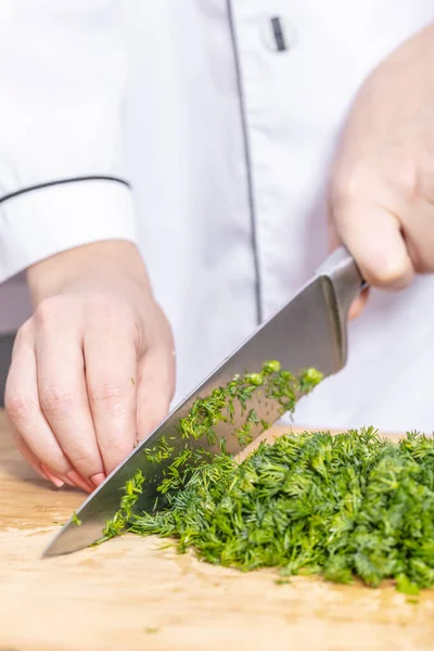 Ahşap bir tahtanın üzerinde doğranmış yeşil dereotu pişirin.