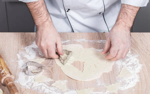 Erkek aşçı Noel kurabiyeleri hazırlıyor, elleri yakın çekim.