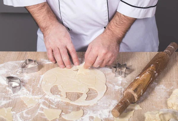Erkek aşçı Noel kurabiyeleri hazırlıyor, elleri yakın çekim.