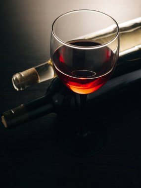 şarap kadehi ve şişeler ahşap bir arka planda