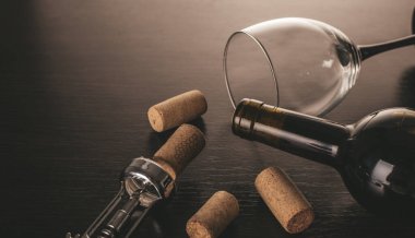 Ahşap arka planda bir şişe şarap ve tirbuşon.