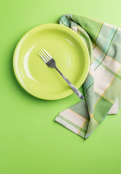 绿色盘子与叉子和餐巾在绿色背景上面看法 — 图库照片