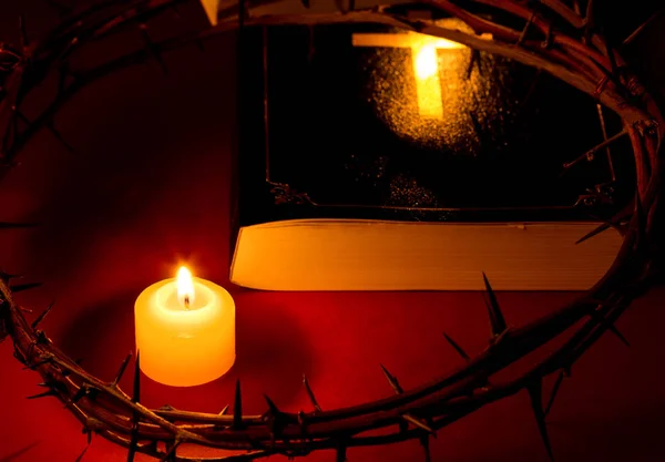 Crown of Thorns of Jesus Christ put on the Bible beside a candle — Stock Photo, Image