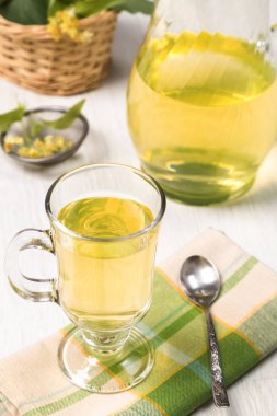 Yeşil çay çiçek ve yeşil yapraklar ile fincan.