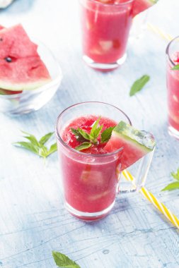Yaz içecekleri karpuz ile nane yaprakları mavi bir tablo üzerinde