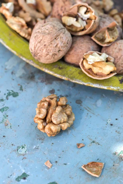 Walnut kernels and whole walnuts on rustic old table — Stock Photo, Image