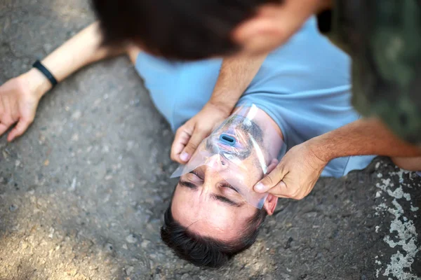 Man giving first aid to a person by using the savior's handkerch — Stock Photo, Image