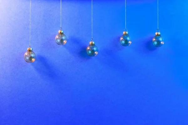 Hanged Christmas baubles on blue background. — Stock Photo, Image