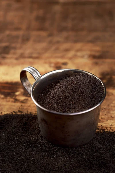 Poppy seed in the mug on a wooden background — Stock Photo, Image