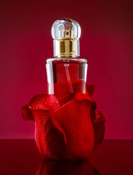 赤の背景にバラの花びら香水瓶 — ストック写真
