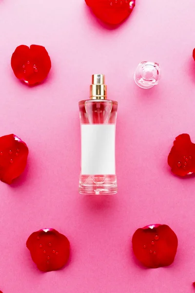 赤い背景の上のバラの花びら香水瓶のトップ ビュー — ストック写真
