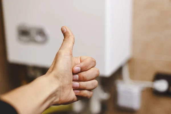 Persona cerca de la calefacción central con el pulgar levantado en gratitud —  Fotos de Stock