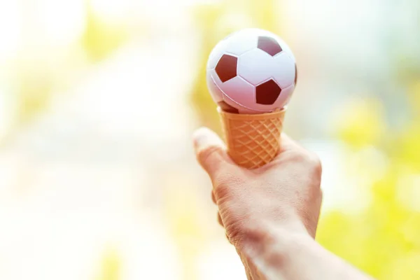 Persona has a ice cream cornet with soccer ball — Stock Photo, Image