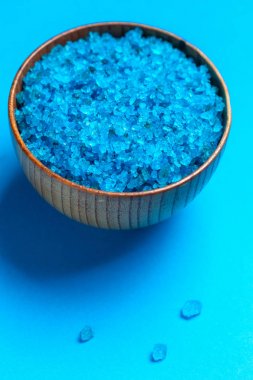 Mavi arka plan üzerinde mavi banyo tuzu ile Kase