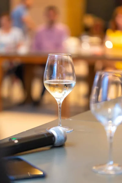 餐桌上的话筒旁边放着一副白葡萄酒酒杯 — 图库照片