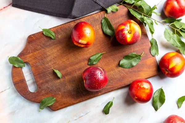 Nectarine proaspete peste chipper de lemn pe masa de marmură — Fotografie, imagine de stoc