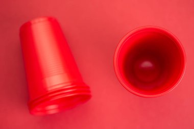 Kırmızı arka planda kırmızı plastik gözlük, üst görünüm
