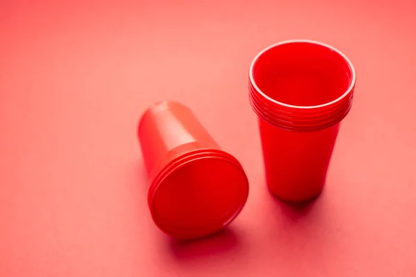 Muitos óculos de plástico vermelho em um fundo vermelho — Fotografia de Stock
