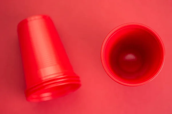 赤い背景に赤いプラスチック製のメガネ、トップビュー — ストック写真