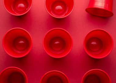 Kırmızı arka planda plastik tek kullanımlık gözlük içme