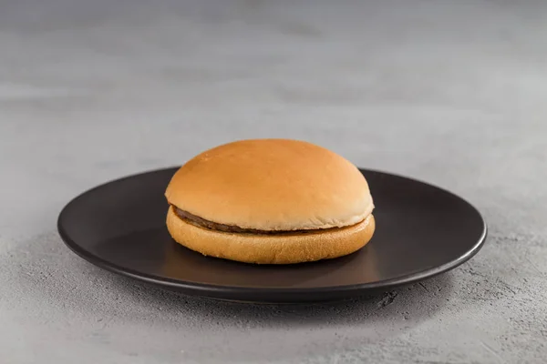 fast food with delicious hamburger on a black ceramic plate.. Close up.