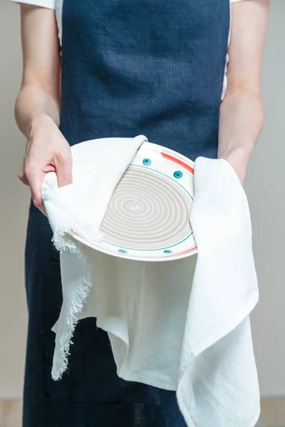 woman cleaning dish with cloth