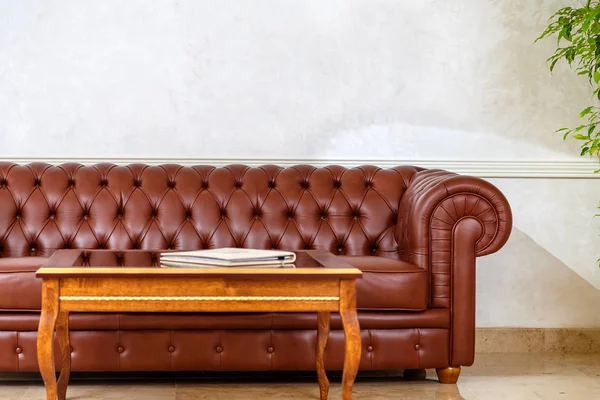 dark leather couch with stitched buttons