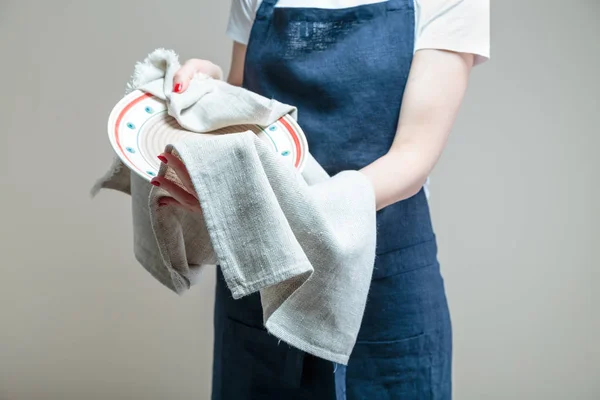 woman cleaning dish with cloth