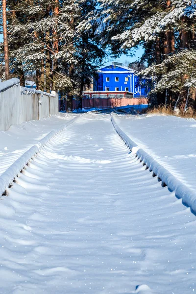 close-up shot of snow covered railway with station building on background