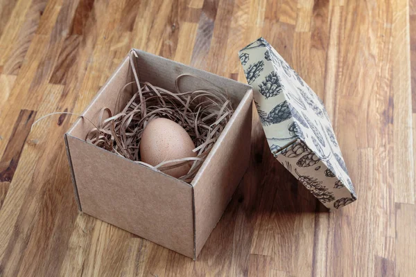 chicken egg in an open cardboard box with a lid, in a soft package