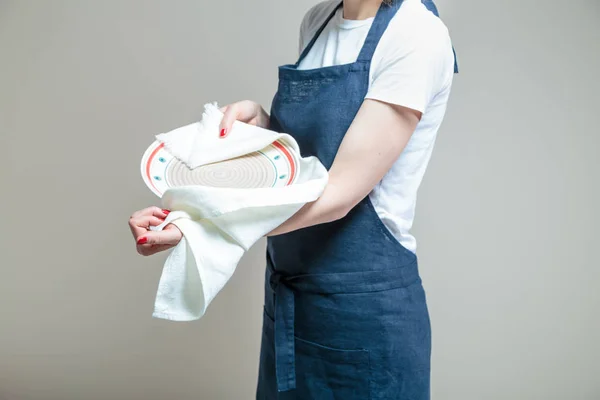 woman cleaning dish with cloth