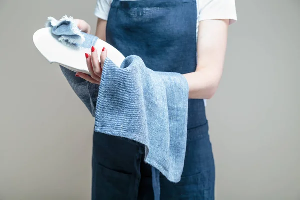 woman cleaning dish with cloth