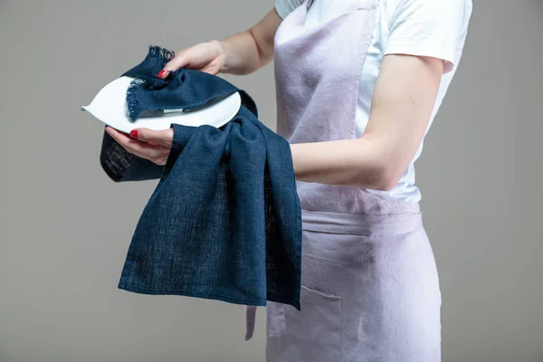 woman cleaning dish with cloth