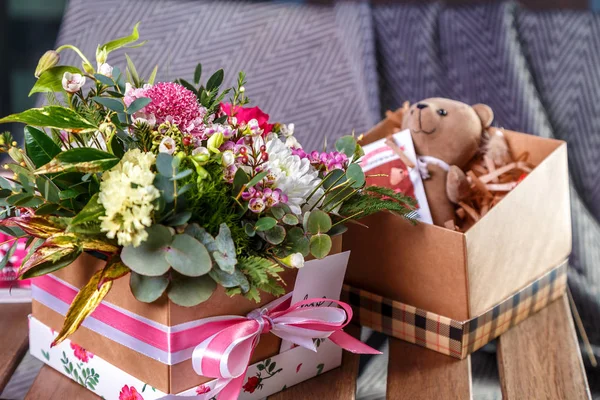 close-up shot of beautiful assorted flowers bouquet and teddy bear in box