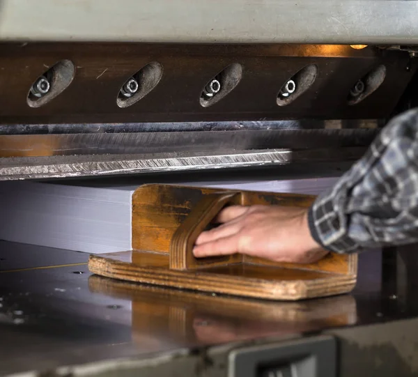 Front view of a paper guillotine in commercial printing industry. Hydraulic industrial guillotine. Selective focus.