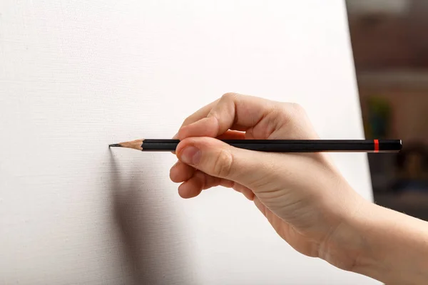 cropped shot of artist drawing on blank paper with pencil