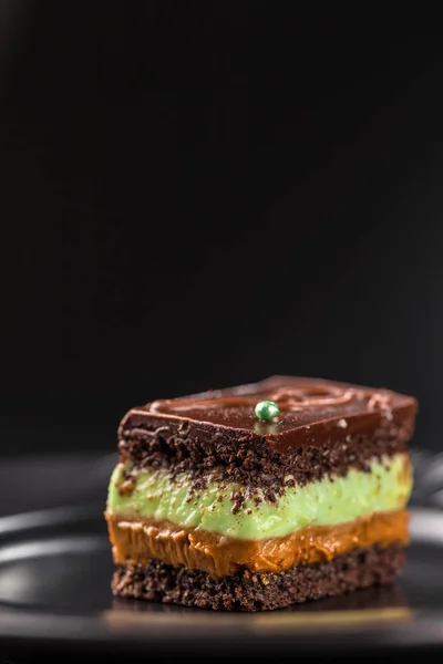 Chocolate biscuit cake with pistachio cream and boiled condensed milk. Selective focus.