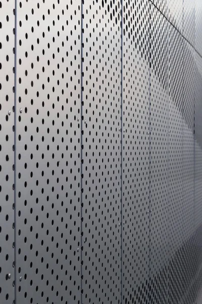 Perforated metal panel. Facing of buildings and structures perforated metal siding. Vertical.