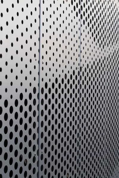 Perforated metal panel. Facing of buildings and structures perforated metal siding. Vertical.