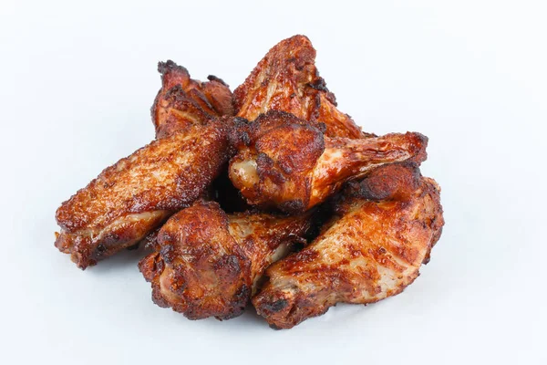 Zblízka Pečené kuřecí křídla na bílém pozadí. Vaření kuřecí masíčka křídla pro sváteční večírek. — Stock fotografie