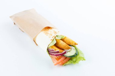 Lavaş ve humus kesme tahtası üzerinde bir kase patates ve sebze (salatalık, domates, salata) sarılı. Geleneksel Arap yemekleri. Yakın çekim görünümü.