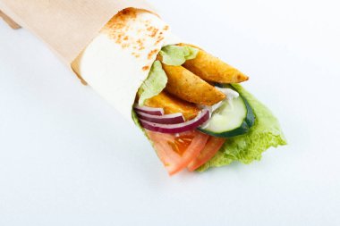 Lavaş ve humus kesme tahtası üzerinde bir kase patates ve sebze (salatalık, domates, salata) sarılı. Geleneksel Arap yemekleri. Yakın çekim görünümü.