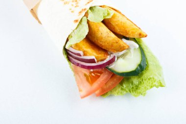 Lavaş ve humus kesme tahtası üzerinde bir kase patates ve sebze (salatalık, domates, salata) sarılı. Geleneksel Arap yemekleri. Yakın çekim görünümü.