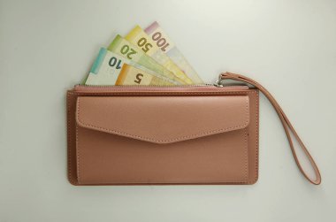 Beyaz arka planda para ile pembe çanta