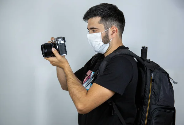Fotoğrafçı beyaz bir arka planda tıbbi bir maskeyle bir rapor hazırlıyor.
