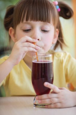 Sevimli küçük kız içecekler içme saman kullanarak suyu