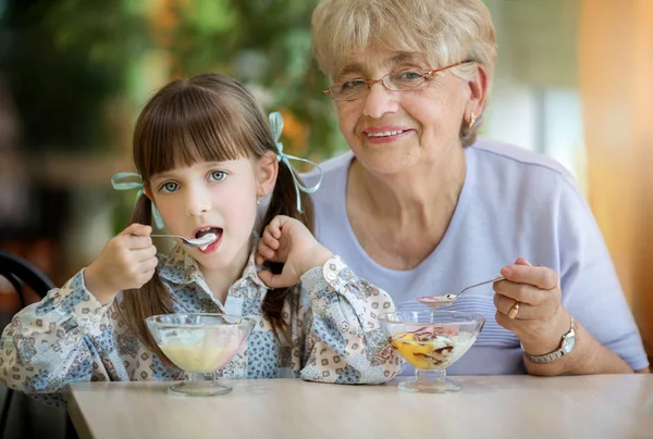 おいしいアイスクリームを一緒に食べる孫娘とシニアの祖母 — ストック写真