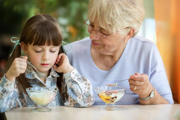 おいしいアイスクリームを一緒に食べる孫娘とシニアの祖母 — ストック写真